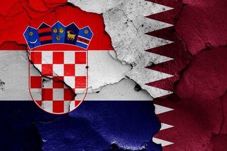 flags of Croatia and Qatar painted on cracked wallの写真素材