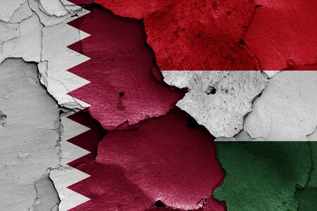flags of Qatar and Hungary painted on cracked wallの写真素材