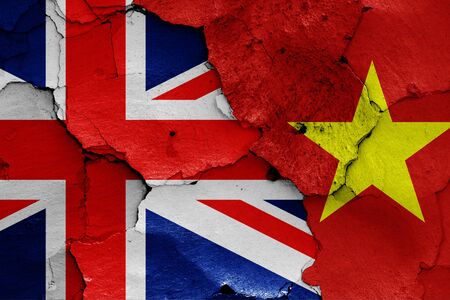 flags of UK and Vietnam painted on cracked wallの写真素材