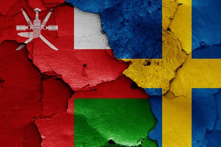 flags of Oman and Sweden painted on cracked wallの写真素材