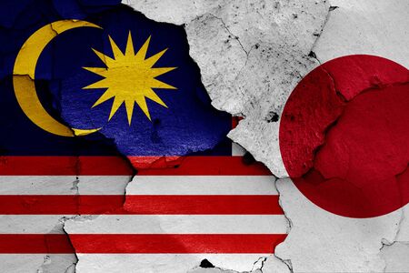 flags of Malaysia and Japan painted on cracked wallの写真素材