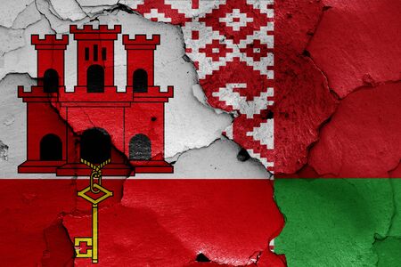 flags of Gibraltar and Belarus painted on cracked wallの写真素材