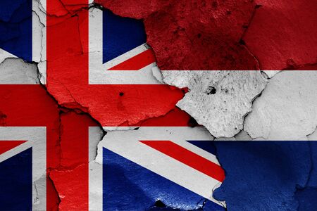 flags of UK and Netherlands painted on cracked wallの写真素材