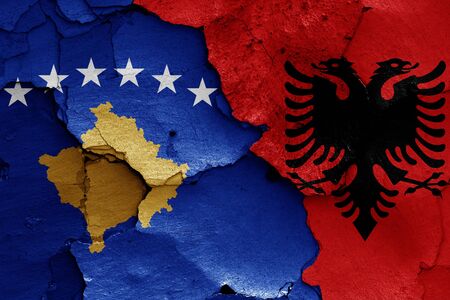 flags of Kosovo and Albania painted on cracked wallの写真素材