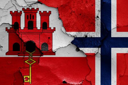 flags of Gibraltar and Norway painted on cracked wallの写真素材