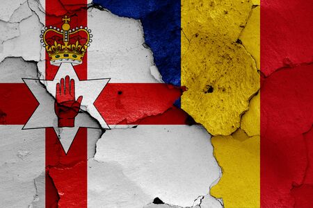 flags of Northern Ireland and Romania painted on cracked wallの写真素材
