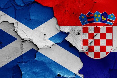 flags of Scotland and Croatia painted on cracked wallの写真素材