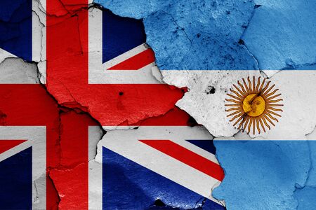 flags of UK and Argentina painted on cracked wallの写真素材