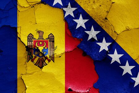 flags of Moldova and Bosnia and Herzegovina painted on cracked wallの写真素材