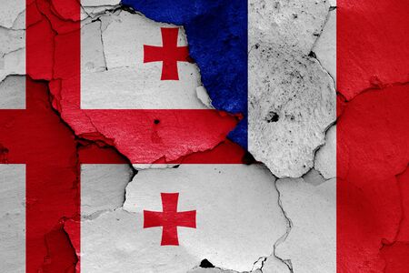 flags of Georgia and France painted on cracked wallの写真素材