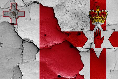 flags of Malta and Northern Ireland painted on cracked wallの写真素材