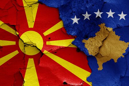 flags of North Macedonia and Kosovo painted on cracked wallの写真素材
