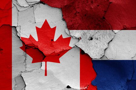 flags of Canada and Netherlands painted on cracked wallの写真素材
