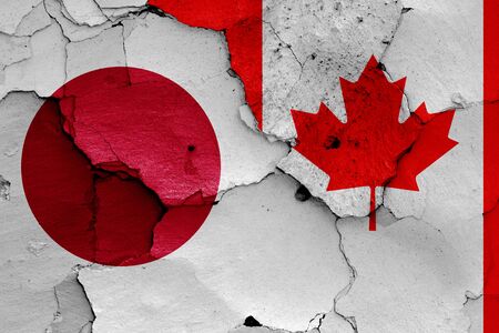 flags of Japan and Canada painted on cracked wallの写真素材