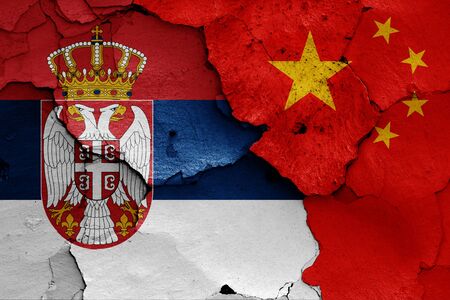 flags of Serbia and China painted on cracked wallの写真素材