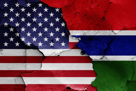 flags of USA and Gambia painted on cracked wallの写真素材