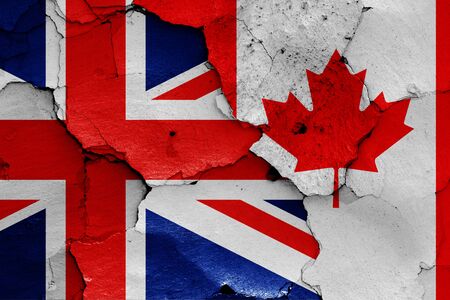 flags of UK and Canada painted on cracked wallの写真素材