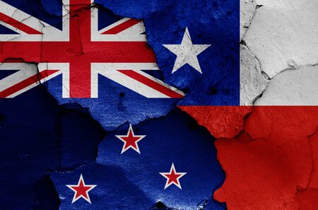 flags of New Zealand and Chile painted on cracked wallの写真素材