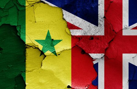 flags of Senegal and UK painted on cracked wallの写真素材