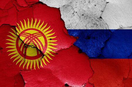 flags of Kyrgyzstan and Russia painted on cracked wallの写真素材