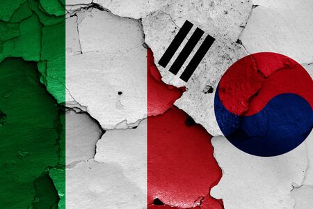 flags of Italy and South Korea painted on cracked wallの写真素材