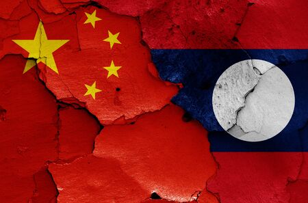 flags of China and Laos painted on cracked wallの写真素材