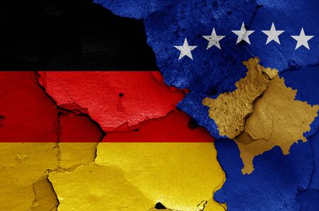 flags of Germany and Kosovo painted on cracked wallの写真素材