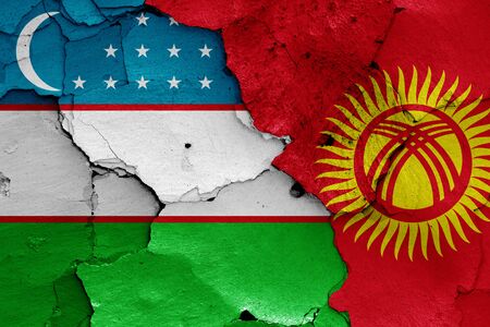 flags of Uzbekistan and Kyrgyzstan painted on cracked wallの写真素材