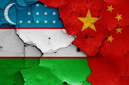 flags of Uzbekistan and China painted on cracked wallの写真素材