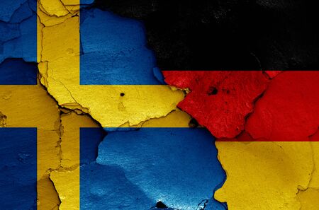 flags of Sweden and Germany painted on cracked wallの写真素材