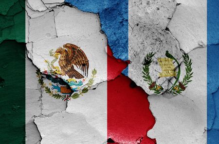 flags of Mexico and Guatemala painted on cracked wallの写真素材