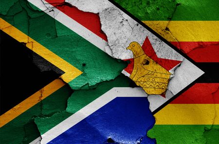 flags of South Africa and Zimbabwe painted on cracked wallの写真素材