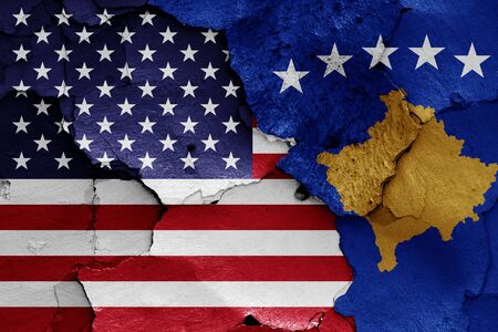 flags of USA and Kosovo painted on cracked wallの写真素材