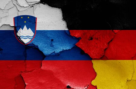 flags of Slovenia and Germany painted on cracked wallの写真素材