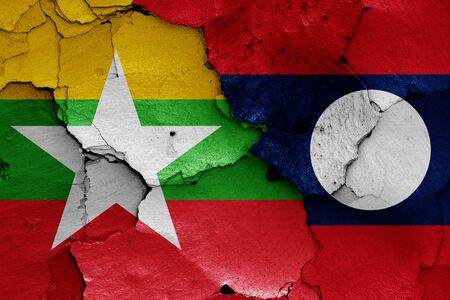 flags of Myanmar and Laos painted on cracked wallの写真素材
