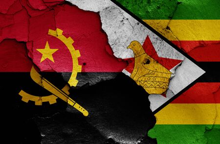 flags of Angola and Zimbabwe painted on cracked wallの写真素材
