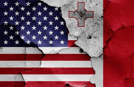 flags of USA and Malta painted on cracked wallの写真素材