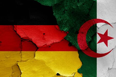 flags of Germany and Algeria painted on cracked wallの写真素材