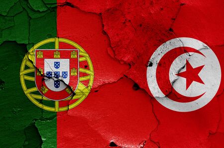 flags of Portugal and Tunisia painted on cracked wallの写真素材