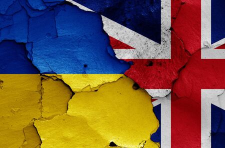flags of Ukraine and UK painted on cracked wallの写真素材