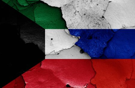 flags of Kuwait and Russia painted on cracked wallの写真素材