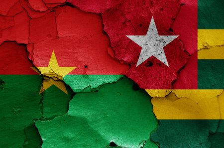 flags of Burkina Faso and Togo painted on cracked wallの写真素材