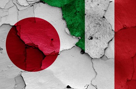 flags of Japan and Italy painted on cracked wallの写真素材