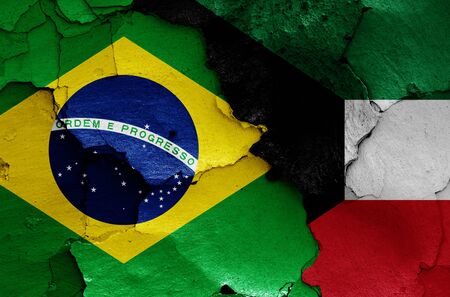 flags of Brazil and Kuwait painted on cracked wallの写真素材