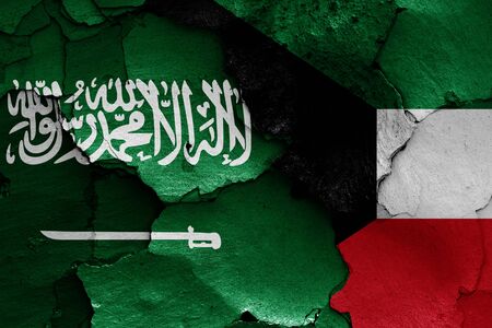 flags of Saudi Arabia and Kuwait painted on cracked wallの写真素材