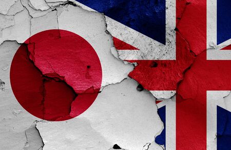 flags of Japan and UK painted on cracked wallの写真素材