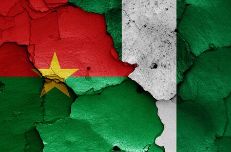 flags of Burkina Faso and Nigeria painted on cracked wallの写真素材