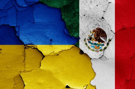flags of Ukraine and Mexico painted on cracked wallの写真素材