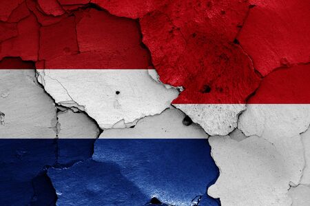 flags of Netherlands and Indonesia painted on cracked wallの写真素材