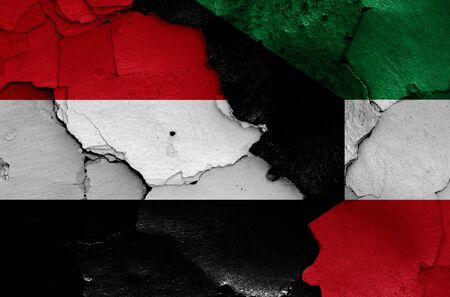 flags of Yemen and Kuwait painted on cracked wallの写真素材